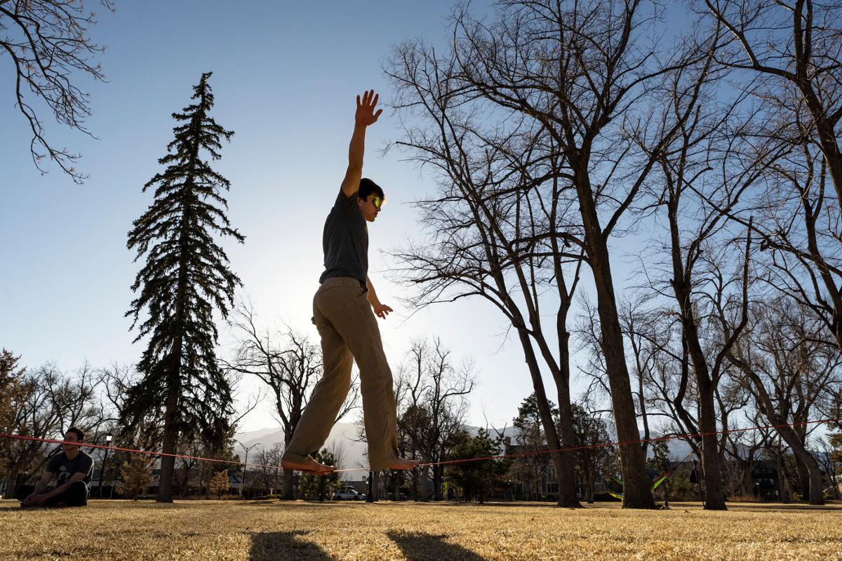 Connor Chen '25 slacklines with schoolmates during a relatively warm winter afternoon in Tava Quad on 2/21/23. Photo by Lonnie Timmons III / Colorado College.